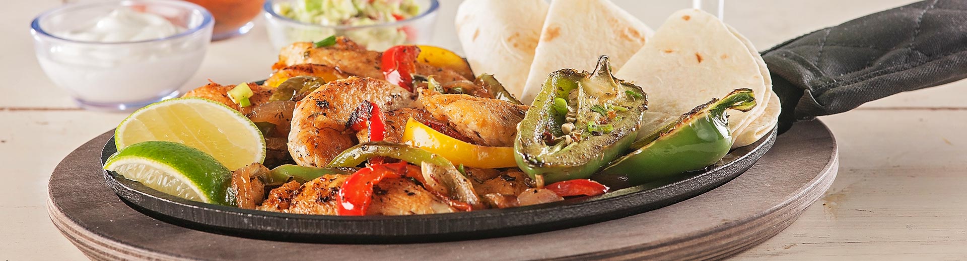 Sizzling shrimp fajitas with peppers and onions on a black skillet